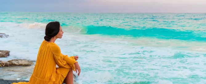 Young beautiful woman in sunset. Happy girl in dress in the evening on the beach
